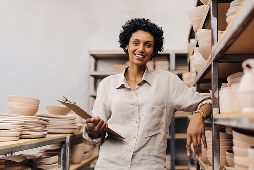 Cheerful ceramic store owner smiling at the camera in her shop