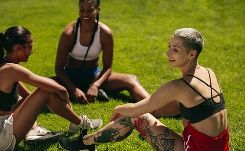 Female soccer players relaxing on the field