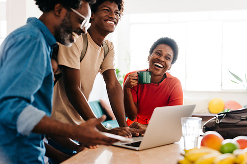 Happy family's morning routine with laptop in kitchen