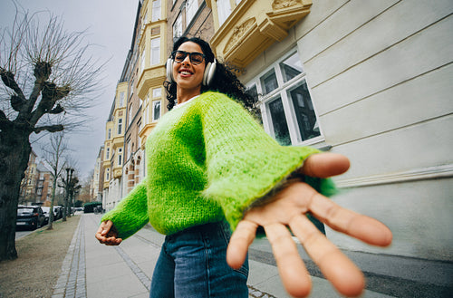 Music follows the woman as she walks through the city with headphones