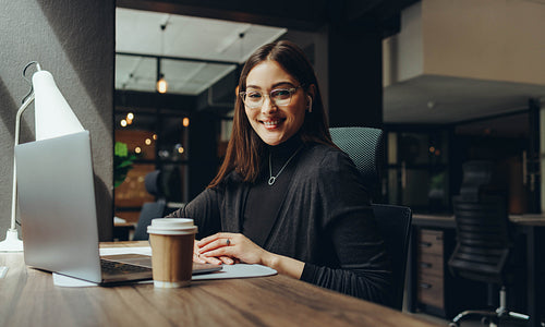 Cheerful young businesswoman working in a coworking office