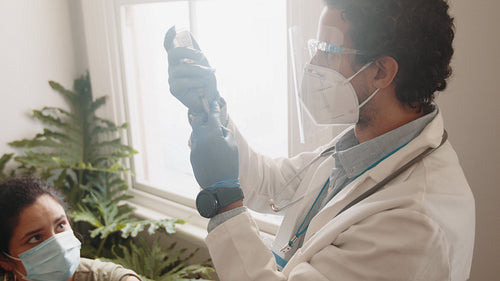 Healthcare in the time of coronavirus: Healthcare professional vaccinating a woman in a home visit