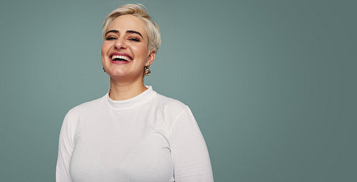 Smiling blonde woman standing in a studio