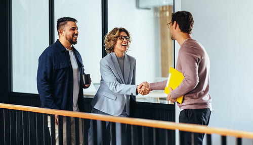 Professional woman shaking hands with a new employee in an office