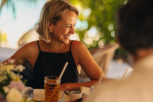 Luxury island vacation with smiling woman enjoying a refreshing drink in tropical paradise setting