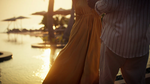 Happy couple dancing and enjoying cocktails at sunset during a romantic tropical vacation