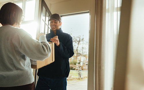 Office woman receives a package from a courier at an office entrance