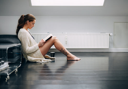 Young lady reading a book at home