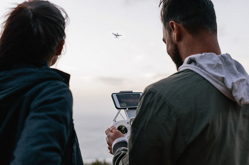 Young couple flying drone outdoors