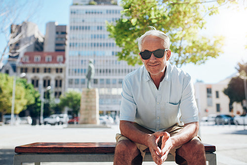 Handsome senior man sitting outdoors in the city