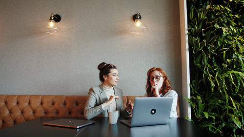 Business women having a discussion with clients in an online meeting