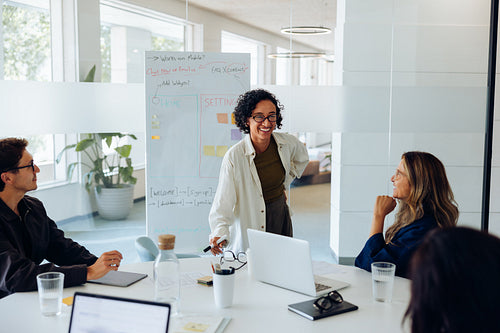 Female ux designer presents to team during meeting