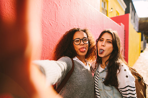 Girls with coloured tongue taking selfie
