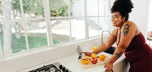 Healthy woman using tablet pc in kitchen