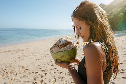 Female tourist on beach vacation with coconut