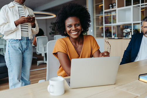 Businesswomen working with her team in a creative boardroom meeting with laptops