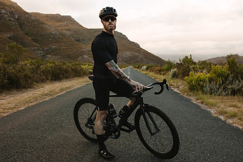 Sportsman with bicycle taking rest from training