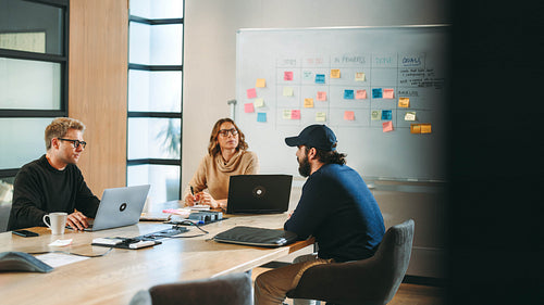 Collaborative business meeting: Creative teamwork and project discussion in tech company office