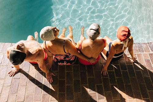 Top view of elderly people relaxing by the poolside