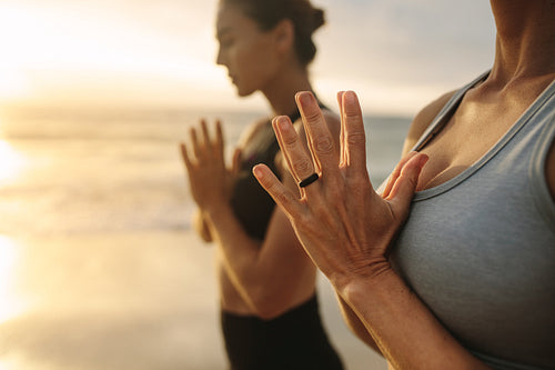 Women practicing yoga at the beach