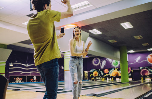 Friends enjoying playing at bowling arena