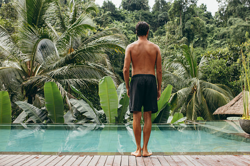 Young man standing on the edge of the pool