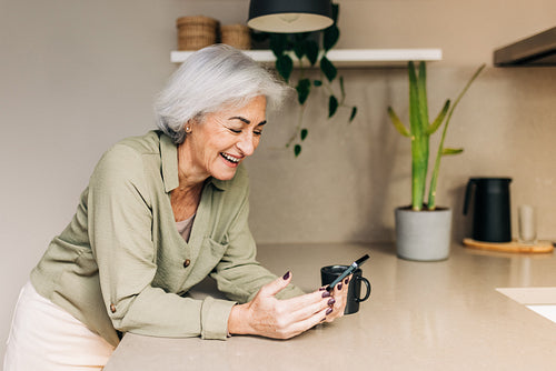 Cheerful senior woman speaking on a video call at home