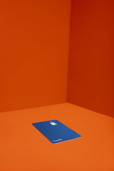 Bold blue bank card on vibrant orange background with striking angular design