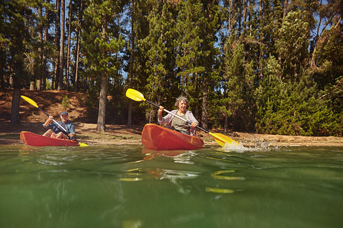 Mature couple canoeing on a lake during a camping trip
