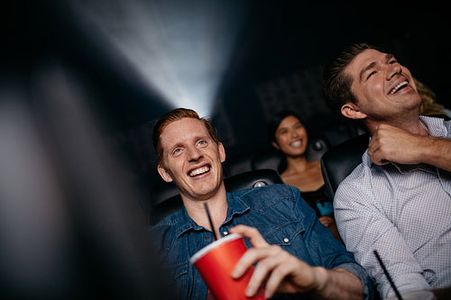 Young men watching movie in cinema