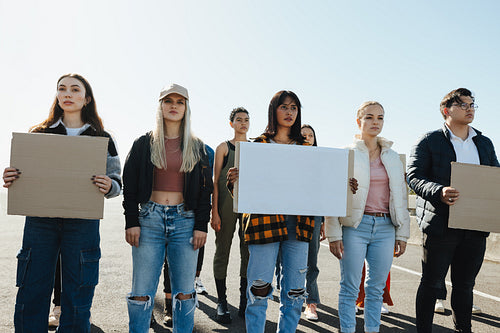 Group of young activists holding blank signs during an outdoor protest