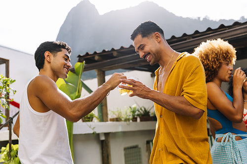 Friends celebrating outdoors with drinks on a sunny weekend day in Rio