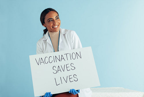 Doctor with "Vaccination saves lives" banner