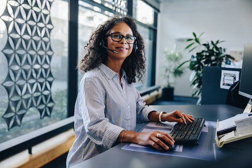 Mature businesswoman with a headset in office