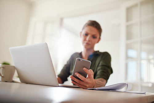 Young woman reading text message on her smart phone