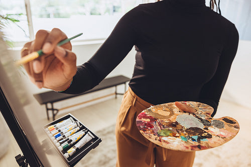 Young painter painting on a canvas