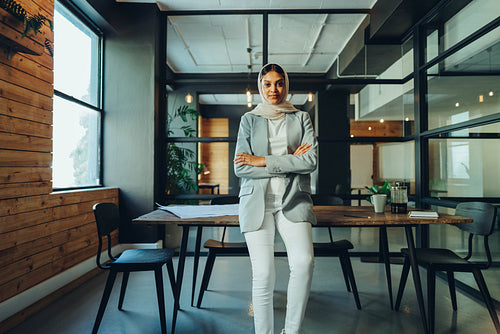 Cheerful female entrepreneur wearing a hijab in an office