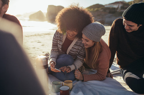 Group of friends at the beach with a smartphone