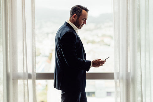 CEO using mobile phone in hotel room