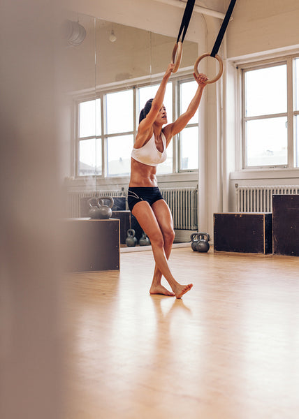 Sporty woman exercising with gymnastic rings
