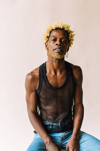 Black gay man sitting posing confidently