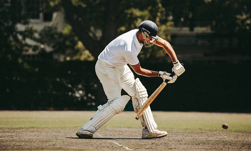 Cricket batsman skillfully defending the wicket during a competitive match