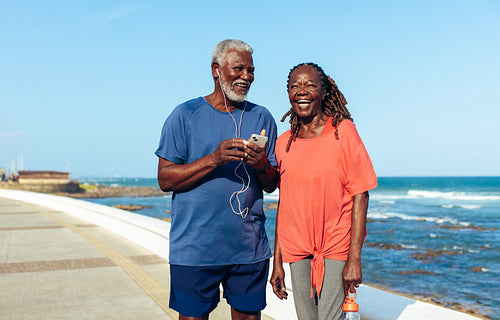 Senior couple enjoying a sunny walk along the ocean promenade
