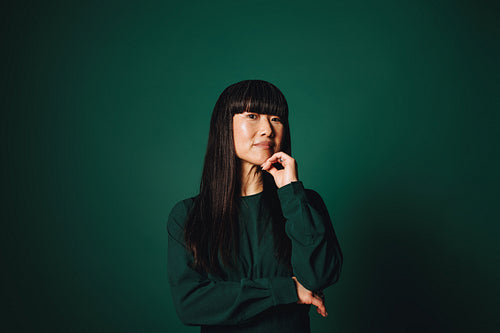 Professional portrait of a mature Asian woman with thoughtful business expression in studio