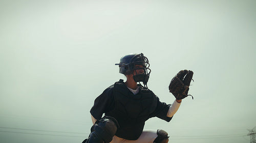 Catcher fielding a baseball and throwing it