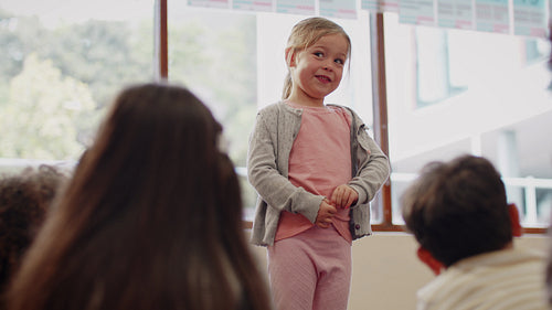 Creating a positive learning environment in a first grade class: Young girl introducing herself to her new classmates in primary school