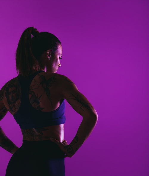 Monochrome portrait of fit woman on purple background