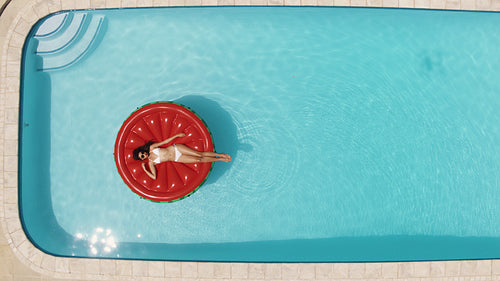 Woman lying on a mattress in the pool