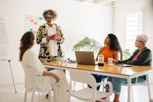 Team leader having a discussion with her colleagues in a boardro