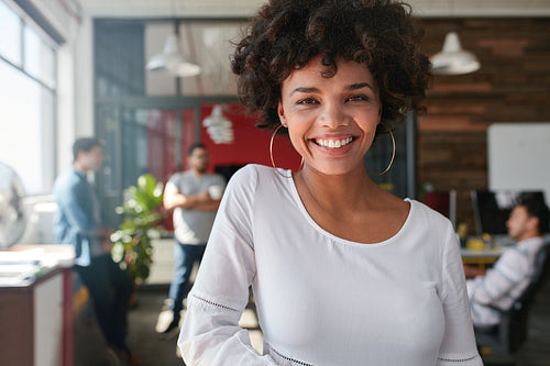 Smiling young african businesswoman with people in background